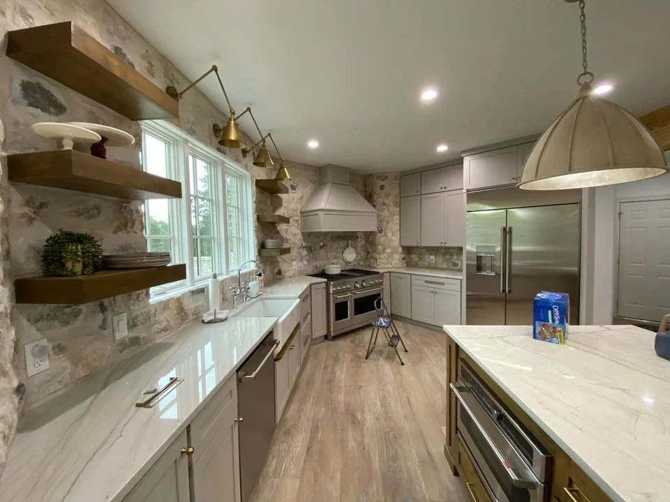 Bright custom kitchen with stone wall and floating wood shelves
